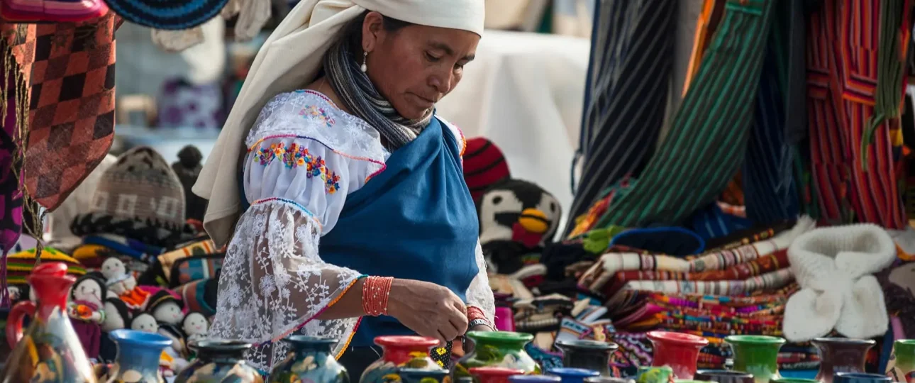 Colorful textile market in Otavalo, surrounded by mountains and local culture.
