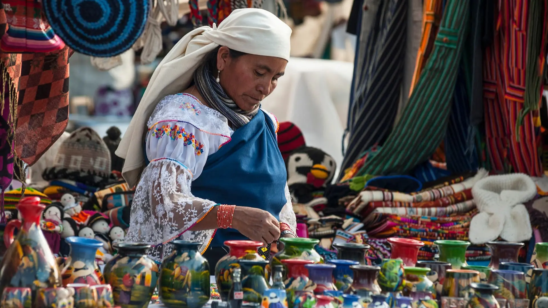 Colorful textile market in Otavalo, surrounded by mountains and local culture.